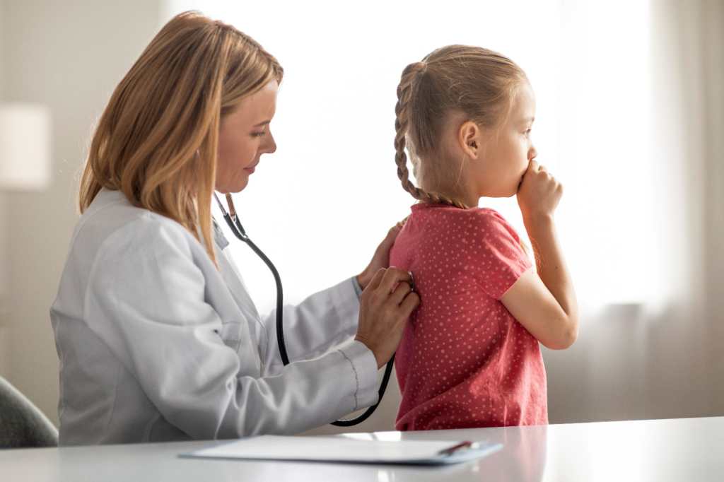 Atención de salud infantil. Pediatra Femenina Médica Examinando A Una Niñita Tos Con Estetoscopio, Terapista Haciendo Un Chequeo Médico Para Un Niño Enfermo En El Hospital, Disparo De Cierre